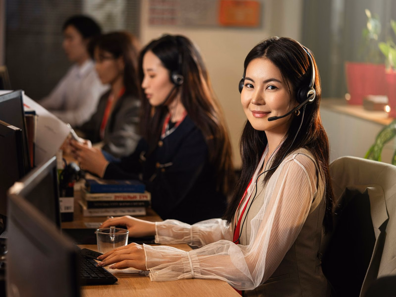 Contact centre agents in headsets working side by side at their desks.
