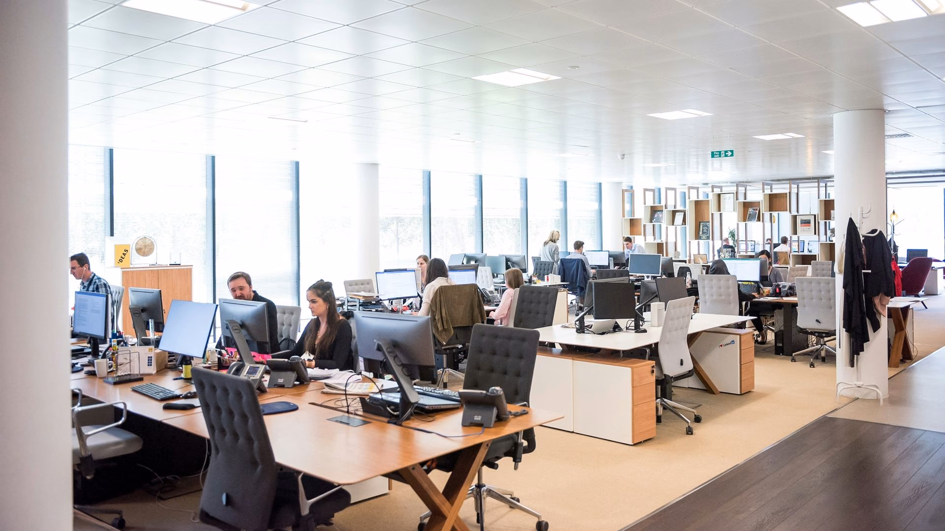 Rows of agents at workstations across a large contact centre floor.